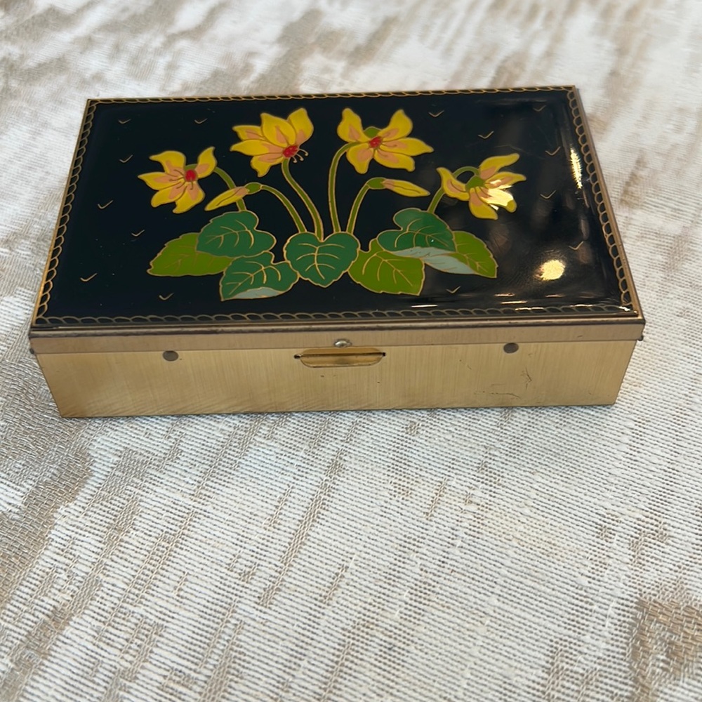 Antique metal box with lacquered top.